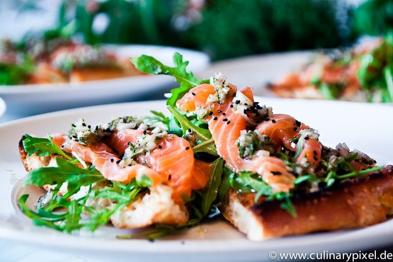 Lachs Sashimi Pizza mit Rucola und Fladenbrot