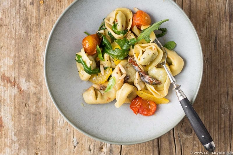 Tortellini mit Rucola, Tomaten, Orangenfilets und Sardellen