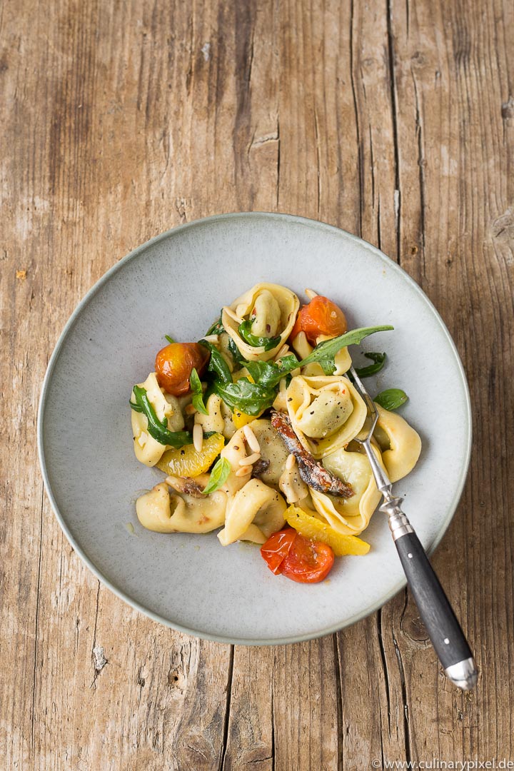 Tortelloni mit Rucola, Tomaten, Orangenfilets und Sardellen